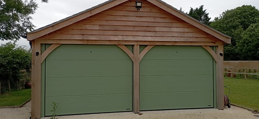 Insulated sectional garage door in a large rib design in green