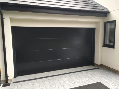 Insulated sectional garage doorin black installed by Henderson in Neston