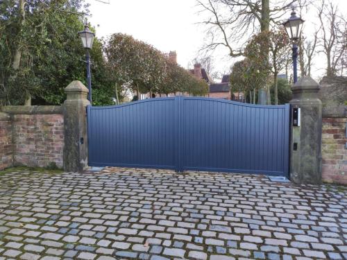 external view made to measure gate in anthracite curved top with underground automation installed by henderson in cheshire